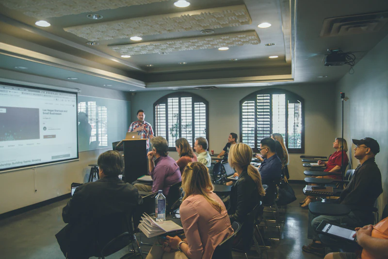 A mentor leading a workshop in a room full of candidates